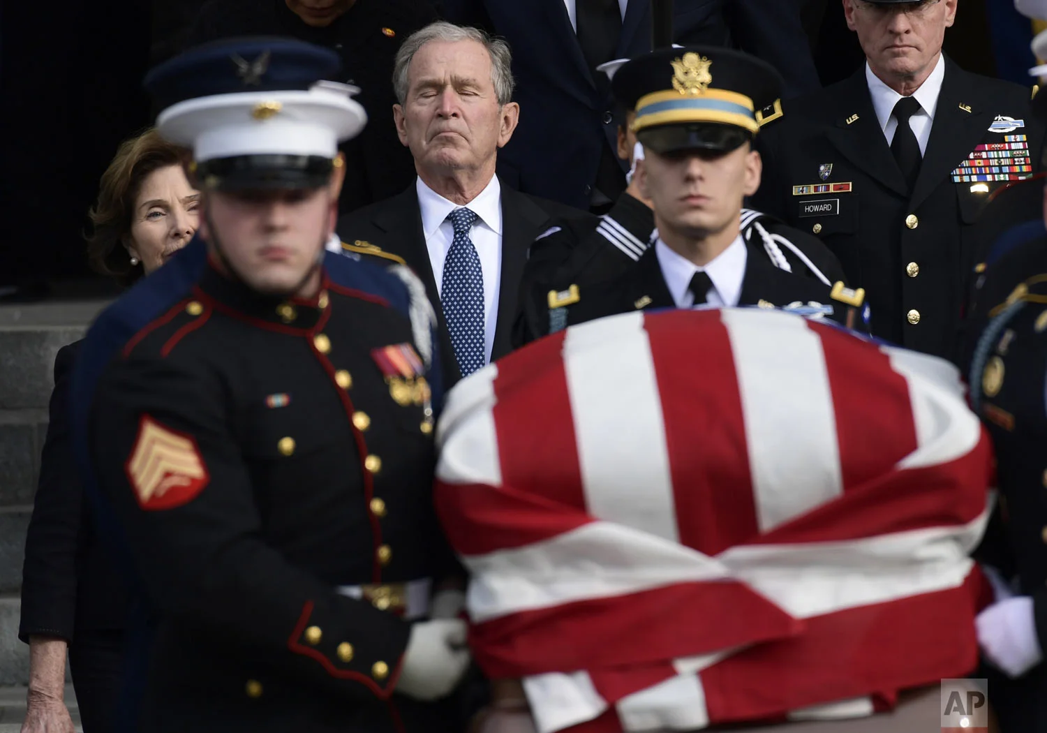 Former President George W. Bush and former first lady Laura Bush, left, follow the casket of former President George H.W. Bush, carried out following a State Funeral at the National Cathedral in Washington, Wednesday, Dec. 5, 2018. (AP Photo/Susan Walsh)