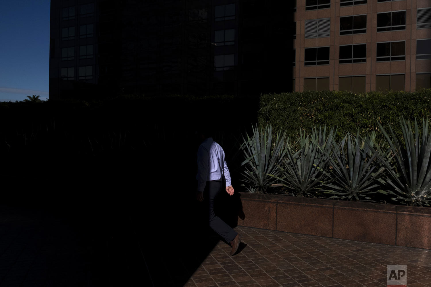  A pedestrian walks into the shadow cast by a building Tuesday, Dec. 4, 2018, in downtown Los Angeles. (AP Photo/Jae C. Hong) 