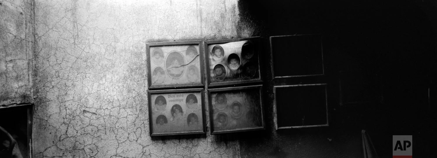 Family portraits burnt by volcanic ash spewed by the Volcan de Fuego or Volcano of Fire hang on the wall of a house on June 8, 2018, in San Miguel Los Lotes, Guatemala. (AP Photo/Rodrigo Abd)