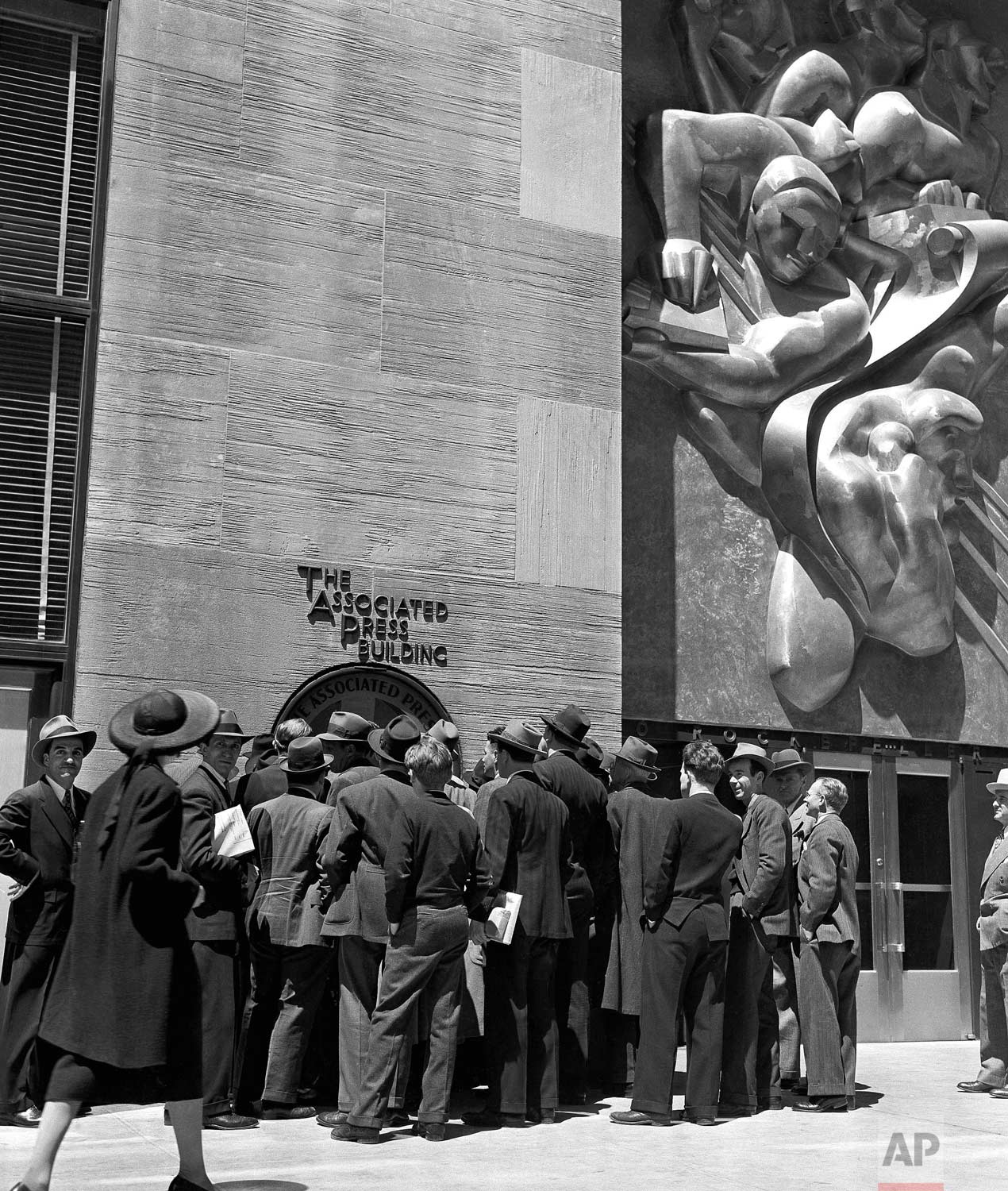  People surround the teletype machine at the Associated Press Building on Rockefeller Plaza in New York City, May 10, 1940. (AP Photo/Robert Kradin) 