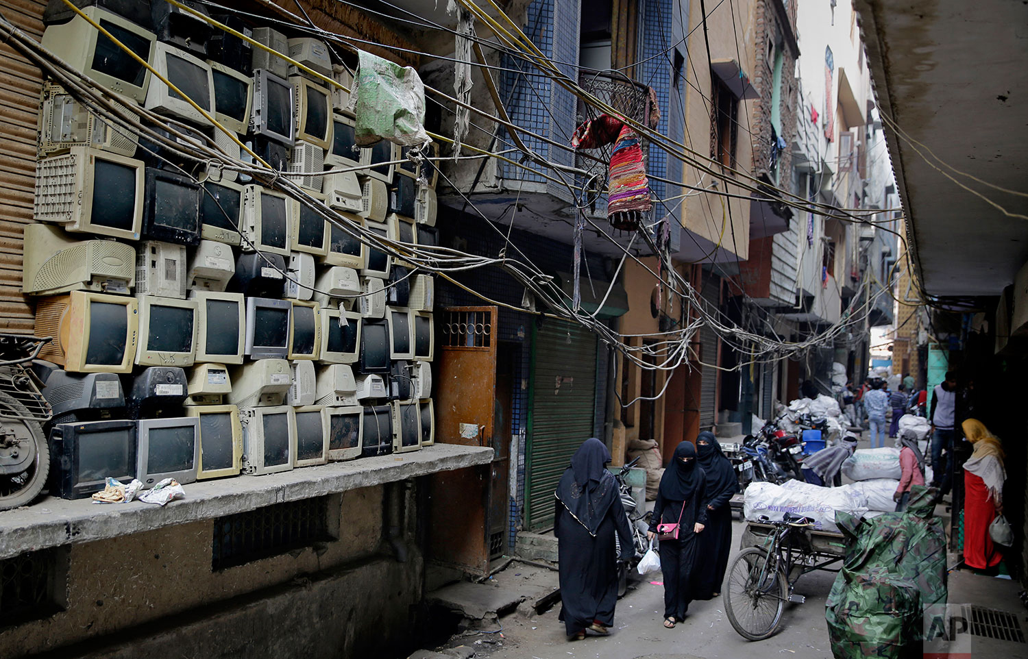 In this Saturday, Dec. 8, 2018 photo, discarded television sets are stacked up in an alleyway in an area known for storing electronic waste in New Delhi, India. (AP Photo/Altaf Qadri)