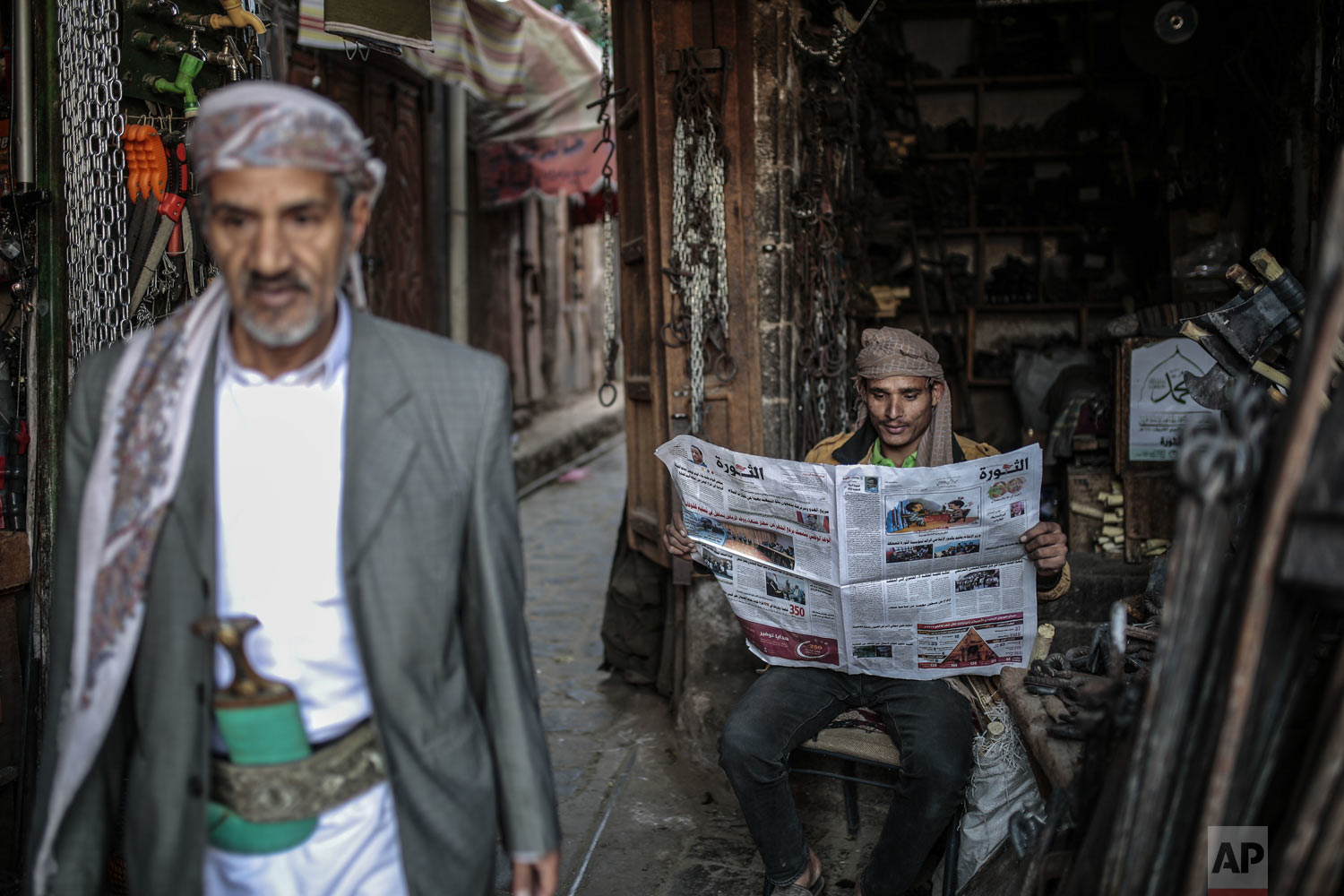  A man reads al-Thawra newspaper at Souq al-Melh marketplace in the old city of Sanaa, Yemen, Tuesday, Dec. 11, 2018. Yemen's warring sides agreed Thursday to an immediate cease-fire in the strategic port city of Hodeida, where fighting has disrupted