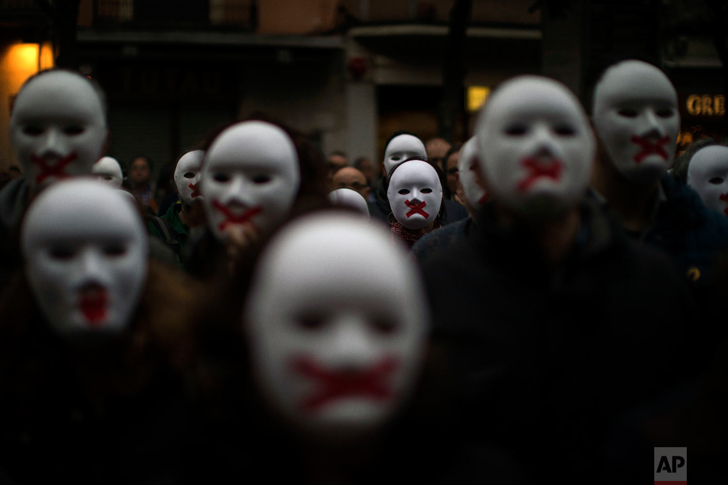  People wear white masks in support of Catalonian politicians jailed on charges of sedition and condemning the arrest of Catalonia's former president, Carles Puigdemont, in Germany, during a protest in Figures, Spain on April. 5, 2018. (AP Photo/Emil
