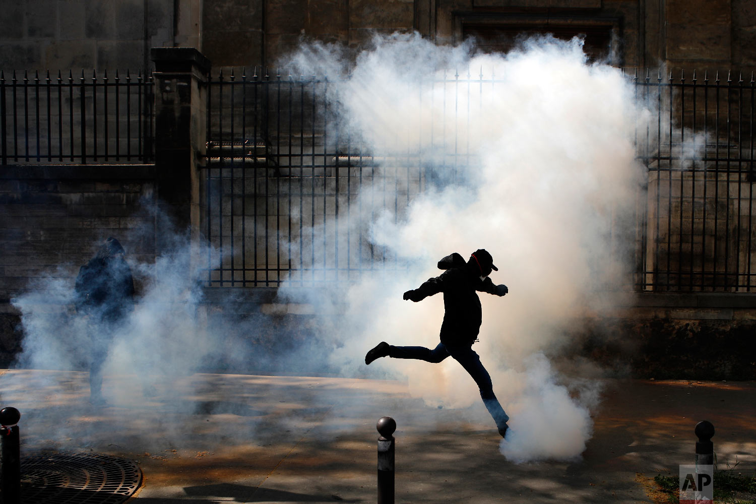  Activist kicks a tear canister gas shot by riot police during a protest in support of the French railway employees, in Paris, France on April 19, 2018. (AP Photo/Francois Mori) 