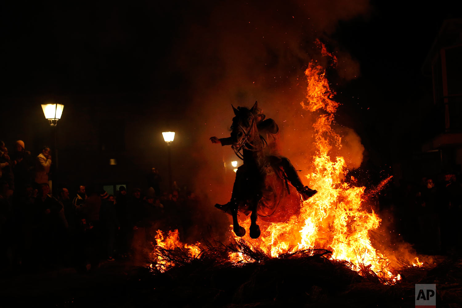  A man rides a horse through a bonfire as part of a ritual in honor of Saint Anthony the Abbot, the patron saint of domestic animals, in San Bartolome de Pinares, Spain on Jan. 16, 2018.(AP Photo/Francisco Seco) 