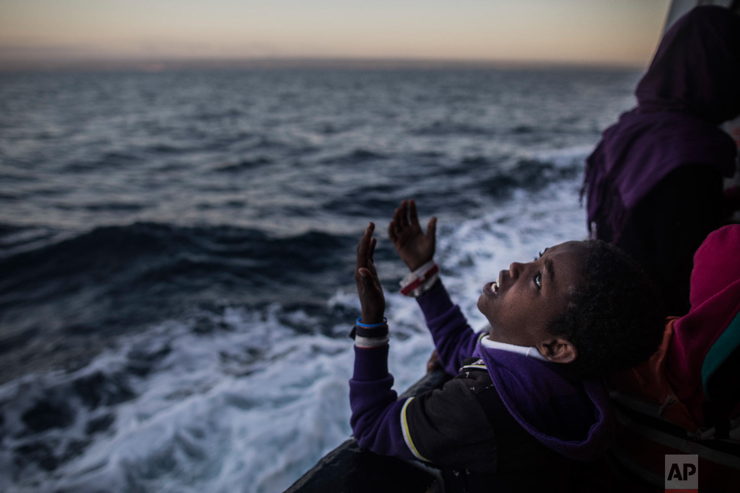  A child from Eritrea sings to celebrate his arrival to Europe aboard the Spanish NGO Proactiva Open Arms rescue vessel near Pozzallo, Sicily, Italy on Jan. 18, 2018. (AP Photo/Santi Palacios) 