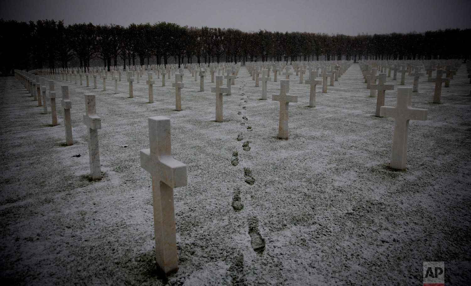  Footsteps are seen as the snow falls at the Meuse-Argonne American WWI cemetery in Romagne-Sous-Montfaucon, France on Oct. 30, 2018. (AP Photo/Virginia Mayo) 