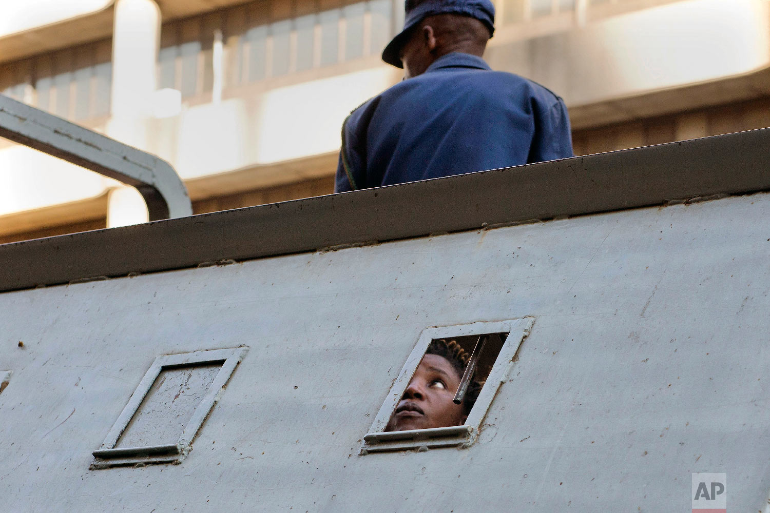  A supporter of Zimbabwean's main opposition party MDC, who was arrested following clashes, is seen detained in a police vehicle outside the MDC headquarters, in Harare on Aug. 2, 2018. (AP Photo/Jerome Delay) 