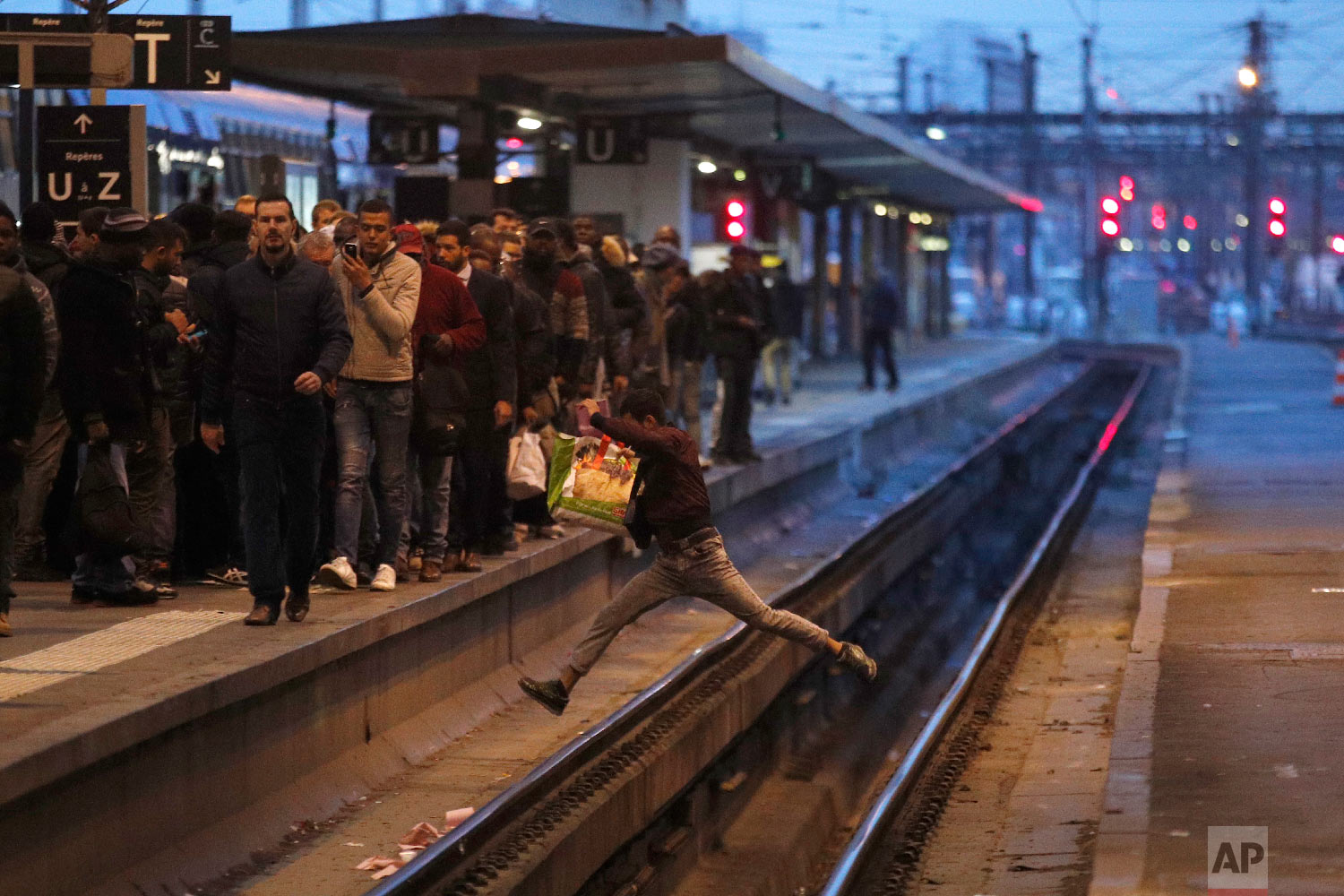  A passenger crosses railroad tracks at rush hour at Gare de Lyon train station, in Paris, France, as union stage a mass strike on April 3, 2018. (AP Photo/Francois Mori) 
