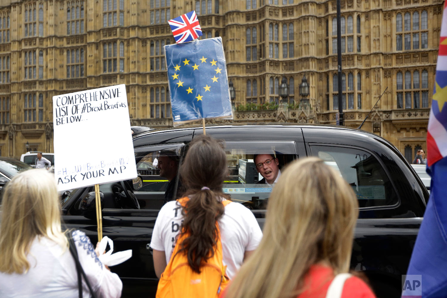  A man in a passing taxi shouts his disagreement at anti-Brexit, pro-EU supporters protesting backdropped by the Houses of Parliament in London on June 20, 2018. (AP Photo/Matt Dunham) 