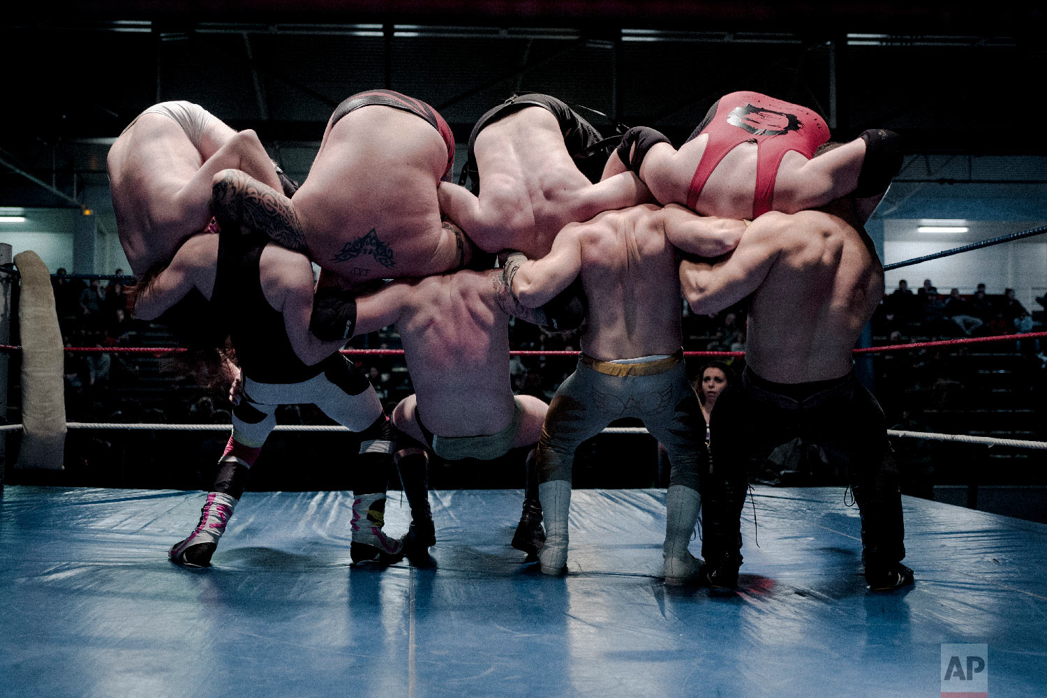  From left, wrestlers Nelson Fernandes, Alex Legrand, Ace Angel, and Zach, bottom, headlock wrestlers Lord Steven Crowley, Darkmundo, Maeven, and PV Red, fight during a wrestling charity gala in Ivry-sur-Seine, south of Paris, France on Feb. 24, 2018
