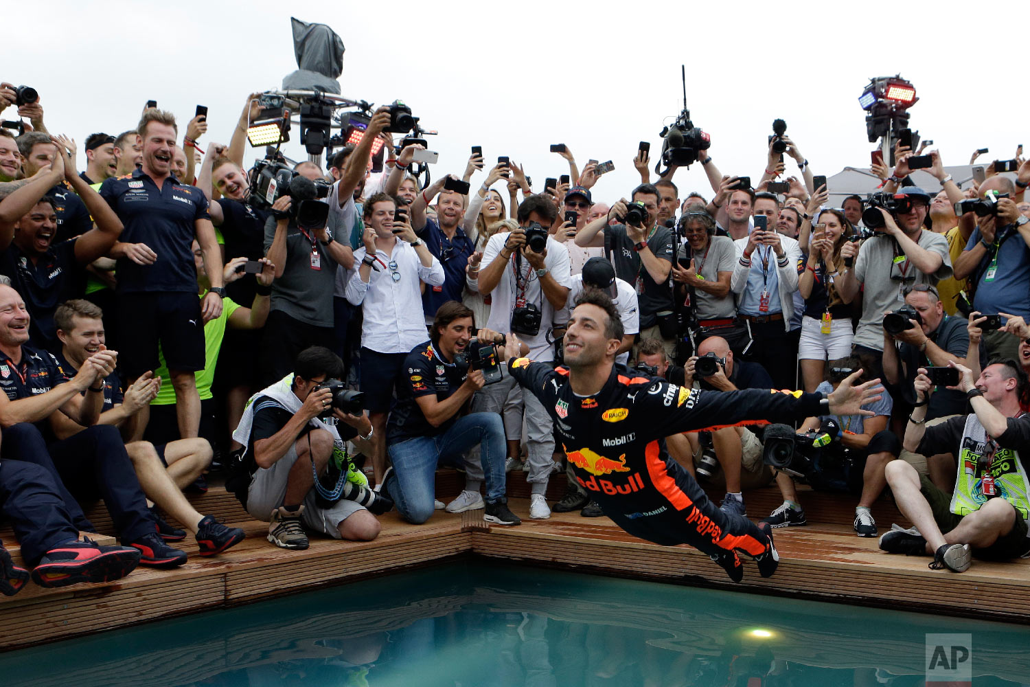  Red Bull driver Daniel Ricciardo of Australia, center, dives into a pool with his team after winning the Formula One race, at the Monaco racetrack, in Monaco on May 27, 2018. (AP Photo/Claude Paris) 