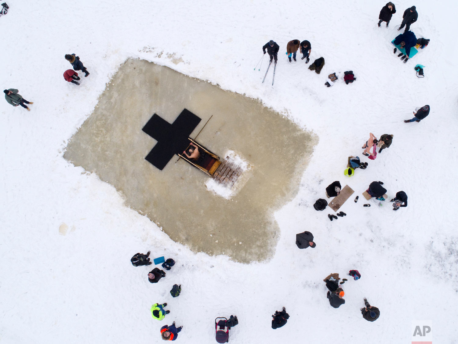 Russian Orthodox believers gather to swim in the icy water on Epiphany at a hole in the form of Orthodox Cross at a lake in Orlino village, 70 kilometers (43 miles) south of St.Petersburg, Russia on Jan. 19, 2018. (AP Photo/Dmitri Lovetsky) 