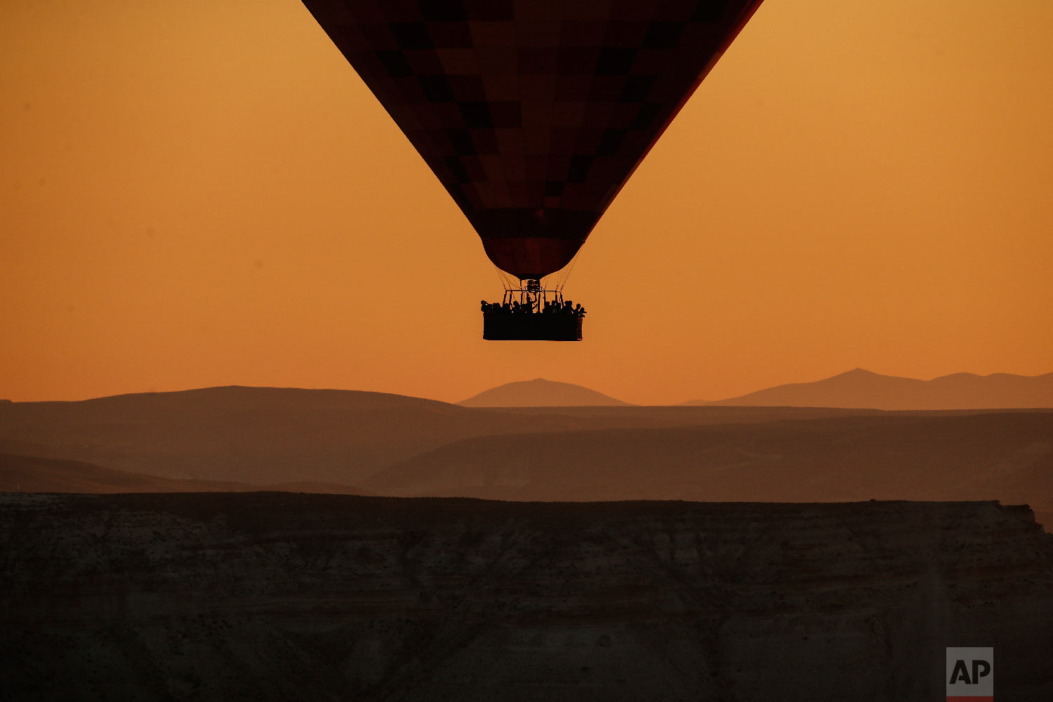  A hot air balloon, carrying tourists, rises into the sky at sunrise in Cappadocia, central Turkey on Aug. 7, 2018. (AP Photo/Emrah Gurel) 
