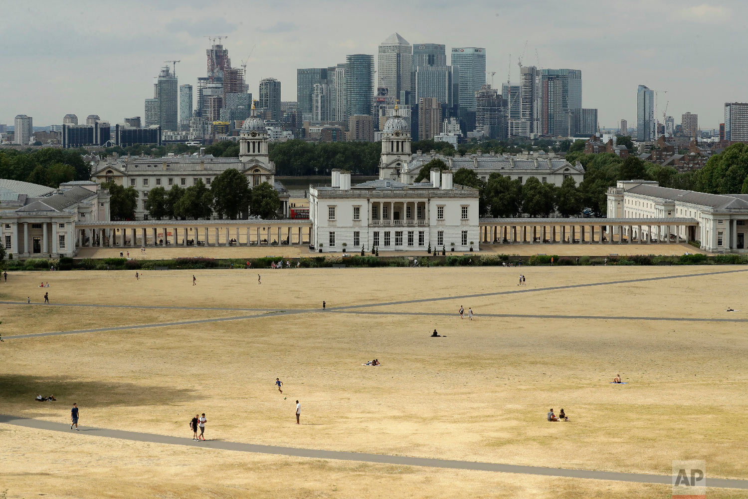  A view shows parched grass from the lack of rain in Greenwich Park, backdropped by the Royal Museums Greenwich and the skyscrapers of the Canary Wharf business district, during what has been the driest summer for many years in London on July 24, 201