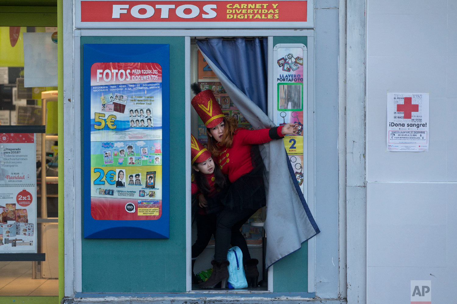  A woman and young girl, dressed in costumes step out from a photo booth before taking part in a "Cabalgata de Reyes," Epiphany parade, in Madrid, Wednesday, Jan. 3, 2018. (AP Photo/Paul White) 