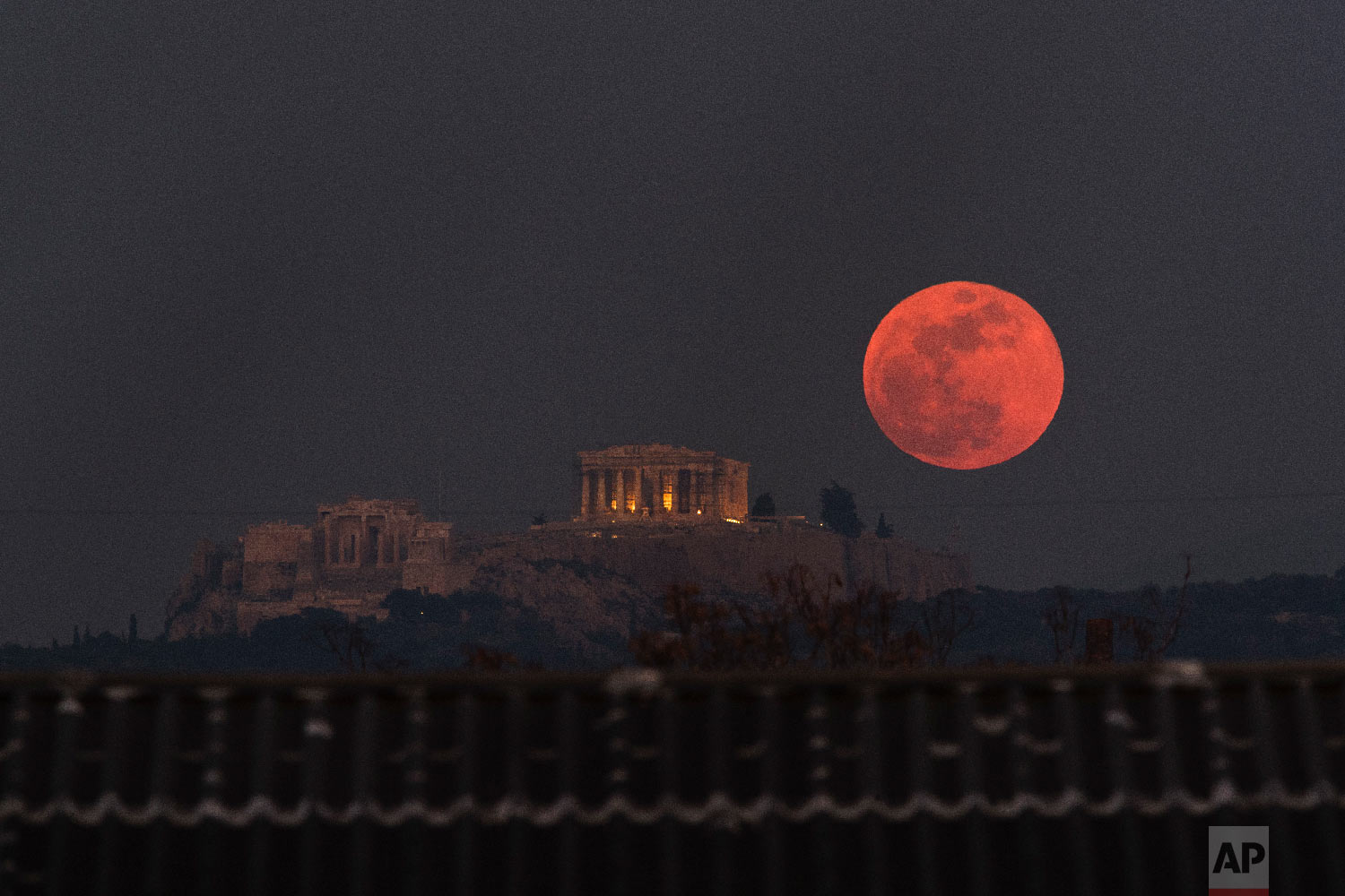  A super blue blood moon rises behind the 2,500-year-old Parthenon temple on the Acropolis of Athens, Greece on an. 31, 2018. (AP Photo/Petros Giannakouris) 