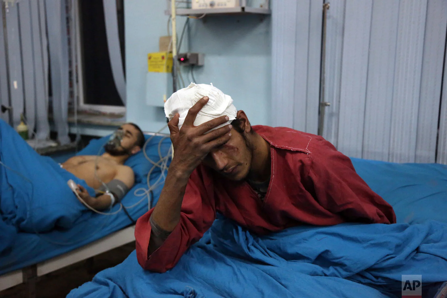 Injured men receive treatment at a hospital after a suicide bombing in Kabul, Afghanistan, Nov. 20, 2018. (AP Photo/Rahmat Gul)