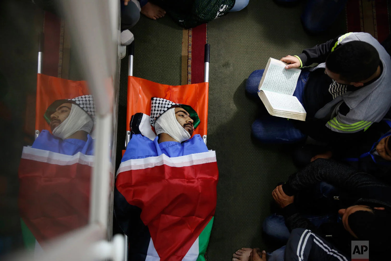 Palestinians pray by the body of Mohammed Habali 22, during his funeral in the Tulkarem refugee camp near the West Bank city of Tulkarem, Dec. 4, 2018. (AP Photo/Majdi Mohammed)