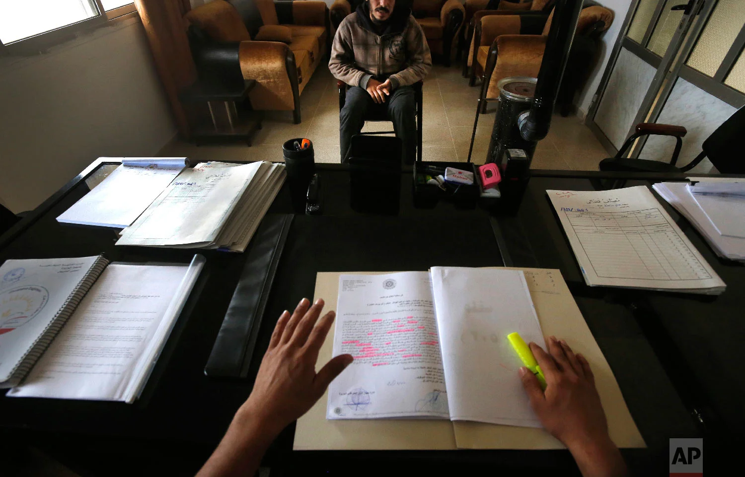 A Syrian 19-year-old former member of the Islamic State group, who declined to be identified, sits opposite a panel of judges in the courtroom of a Kurdish-run terrorism court, in Qamishli, north Syria on April 3, 2018. (AP Photo/Hussein Malla)