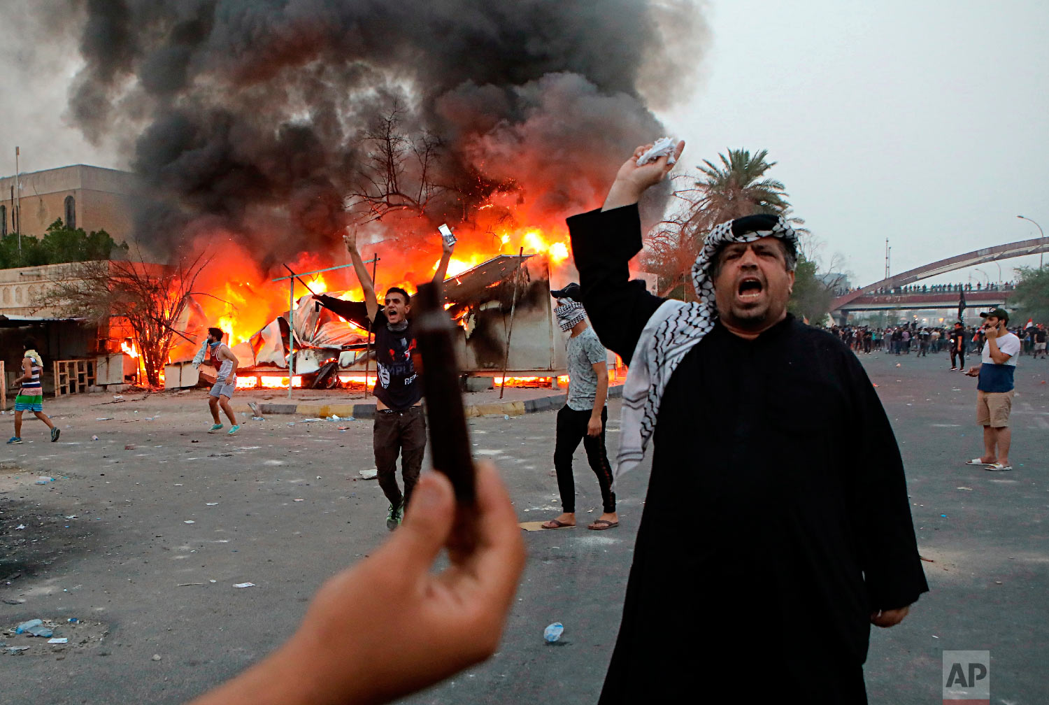 Protesters try to storm and burn the governor's building during protests demanding better public services and jobs, Tuesday, Sept. 4, 2018, in Basra, 340 miles (550 kilometers) southeast of Baghdad, Iraq. (AP Photo/Nabil al-Jurani)