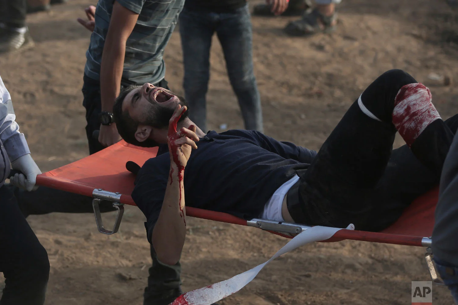 Palestinian medics carry a wounded protester during a protest at the Gaza Strip's border with Israel, Oct. 5, 2018. (AP Photo/Khalil Hamra)