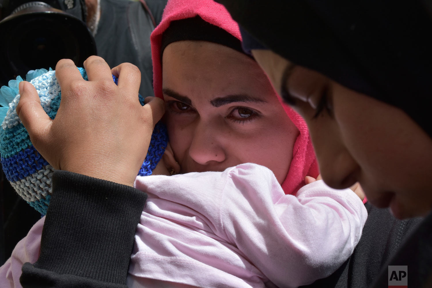 Displaced women who fled the Syrian war wait near the Lebanese-Syrian border as they prepare to return to their village of Beit Jinn in Syria, in Shebaa, southern Lebanon, April, 18, 2018. Hundreds of refugees are headed back to Syria in what they s