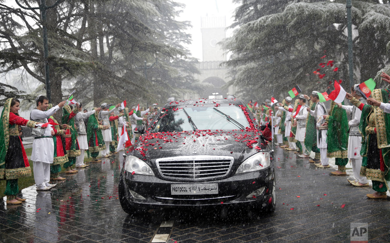 Girls and boys wave flags for Indonesian President, Joko Widodo, at the presidential palace in Kabul, Afghanistan, Jan. 29, 2018. (AP Photo/Massoud Hossaini, Pool)