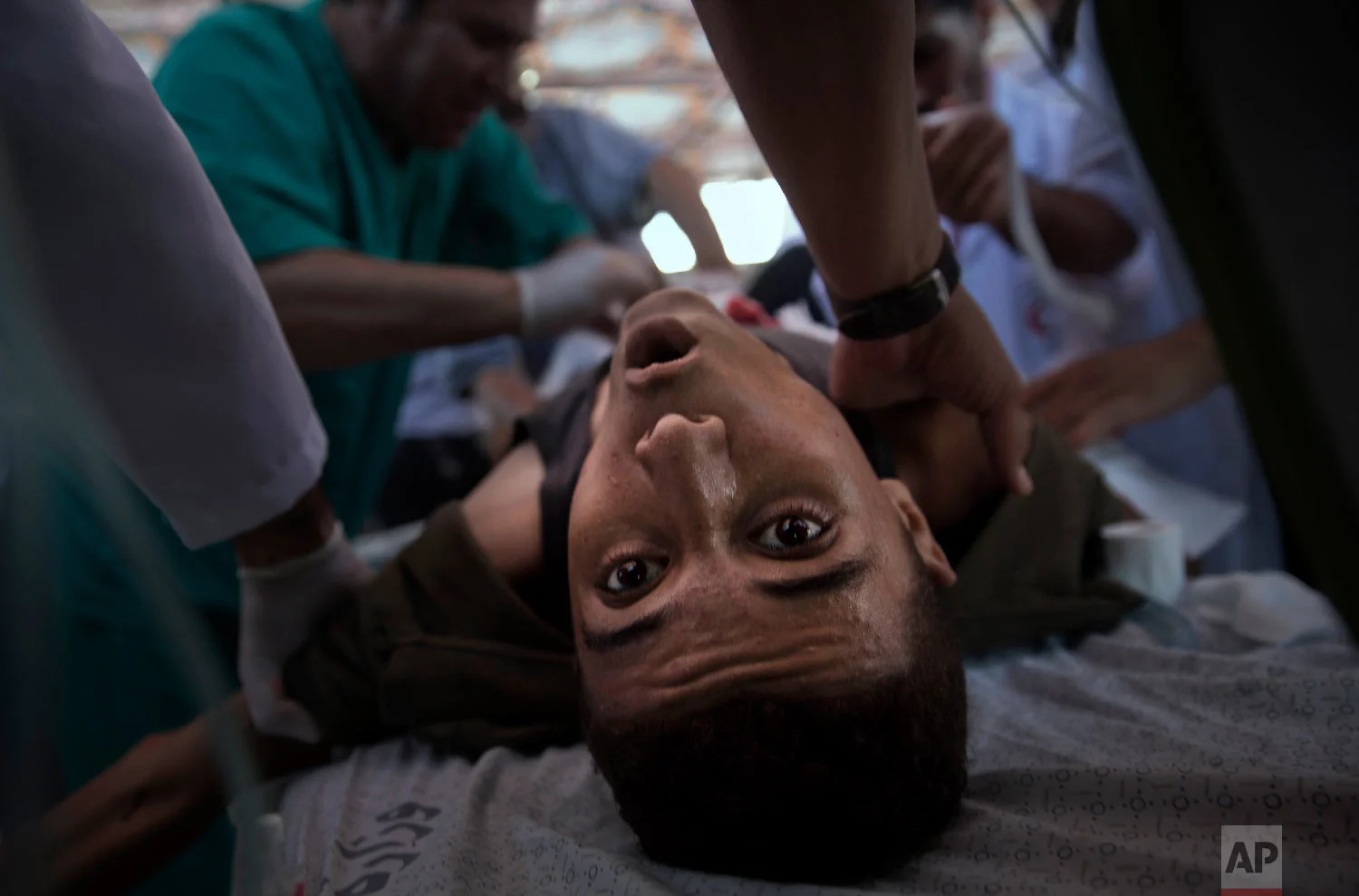 An injured Palestinian youth receives treatment in a field clinic after being shot by Israeli troops during a protest at the Gaza Strip's border with Israel, July 20, 2018. (AP Photo/Khalil Hamra)