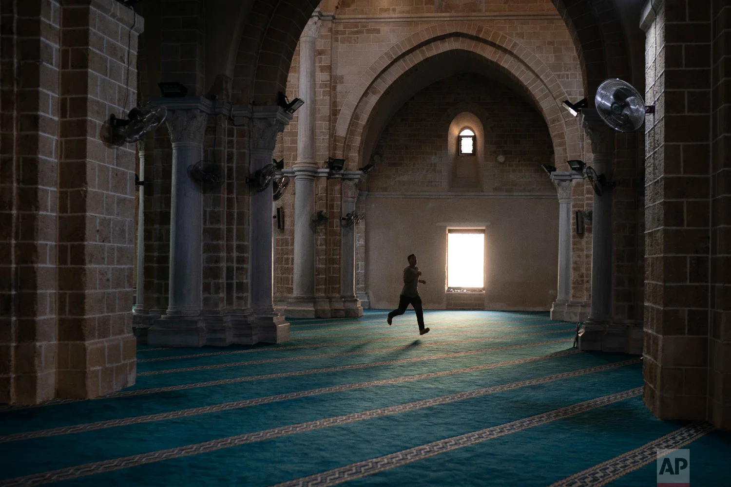 A man runs as he arrives a few minutes late for the afternoon prayer in a mosque in Gaza City, Sept. 14, 2018. (AP Photo/Felipe Dana)