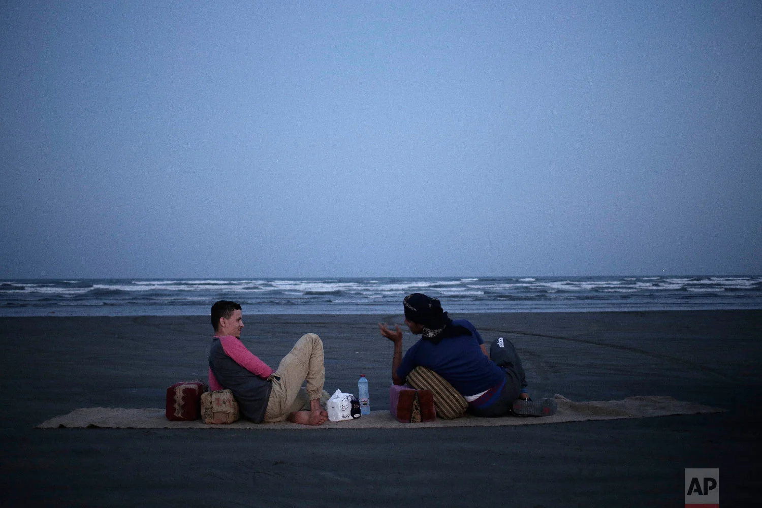 Osama Ahmed, left, and Ahmed Saleh, who both fought during the '2015 battle of Aden' chew Qat by the beach, in Aden, Yemen on Feb. 18, 2018. (AP Photo/Nariman El-Mofty)