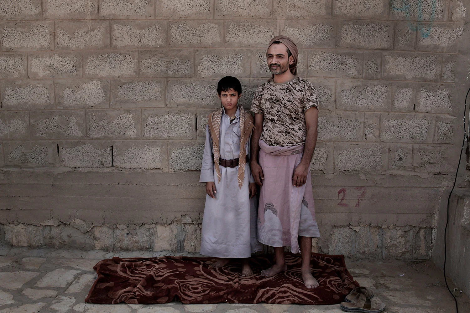 In this July 27, 2018 photo, 14 year-old Abdel Hamid Saleh, and his father pose for a photograph at a camp for displaced persons where they took shelter, in Marib, Yemen, (AP Photo/Nariman El-Mofty)