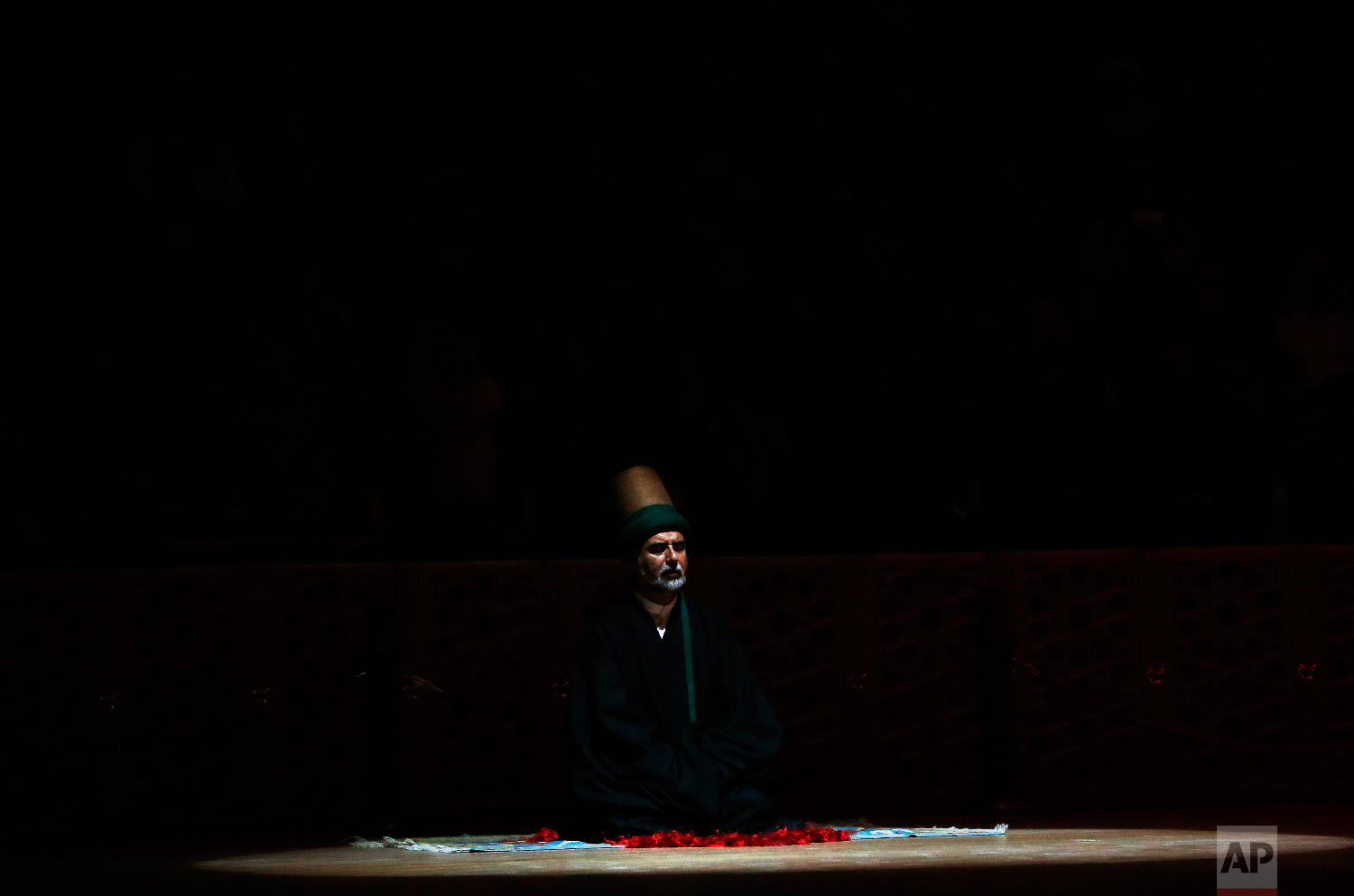 A sheikh of the Mevlevi order of whirling dervishes offers his prayers during a Sheb-i Arus ceremony in Konya, central Turkey, Sunday, Dec. 16, 2018. (AP Photo/Lefteris Pitarakis)