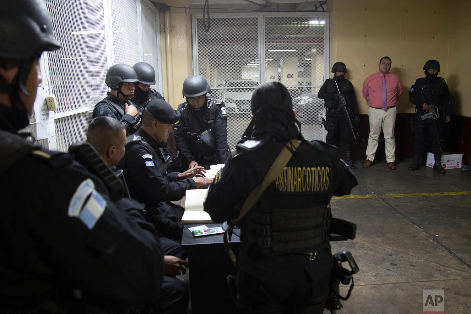 In this Jan. 13, 2018 photo, lawmaker Julio Juarez Ramirez, far right, stands handcuffed at court where he's accused of orchestrating the 2015 murder of two journalists in Guatemala City. Juarez allegedly hired hit men to kill journalist Danilo Efrain Lopez, fearing that his coverage would hurt Juarez's electoral campaign. A second journalist, Federico Benjamin Salazar, also died. (AP Photo/Moises Castillo)