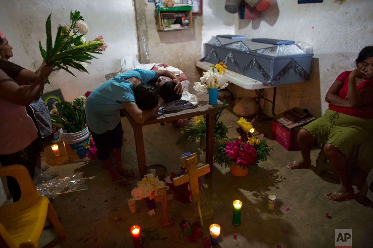 In this Feb. 8, 2018 photo, Maribel Julio Meneses weeps over the body of her son Daniel Julio Julio, a 22-year-old "community police" vigilante who was ambushed and killed while on duty, in the village of Huamuchapa, near Tecoanapa in Guerrero state, Mexico. Fed up with police corruption and drug gang violence, a number of communities have formed citizen police groups. (AP Photo/Rebecca Blackwell)