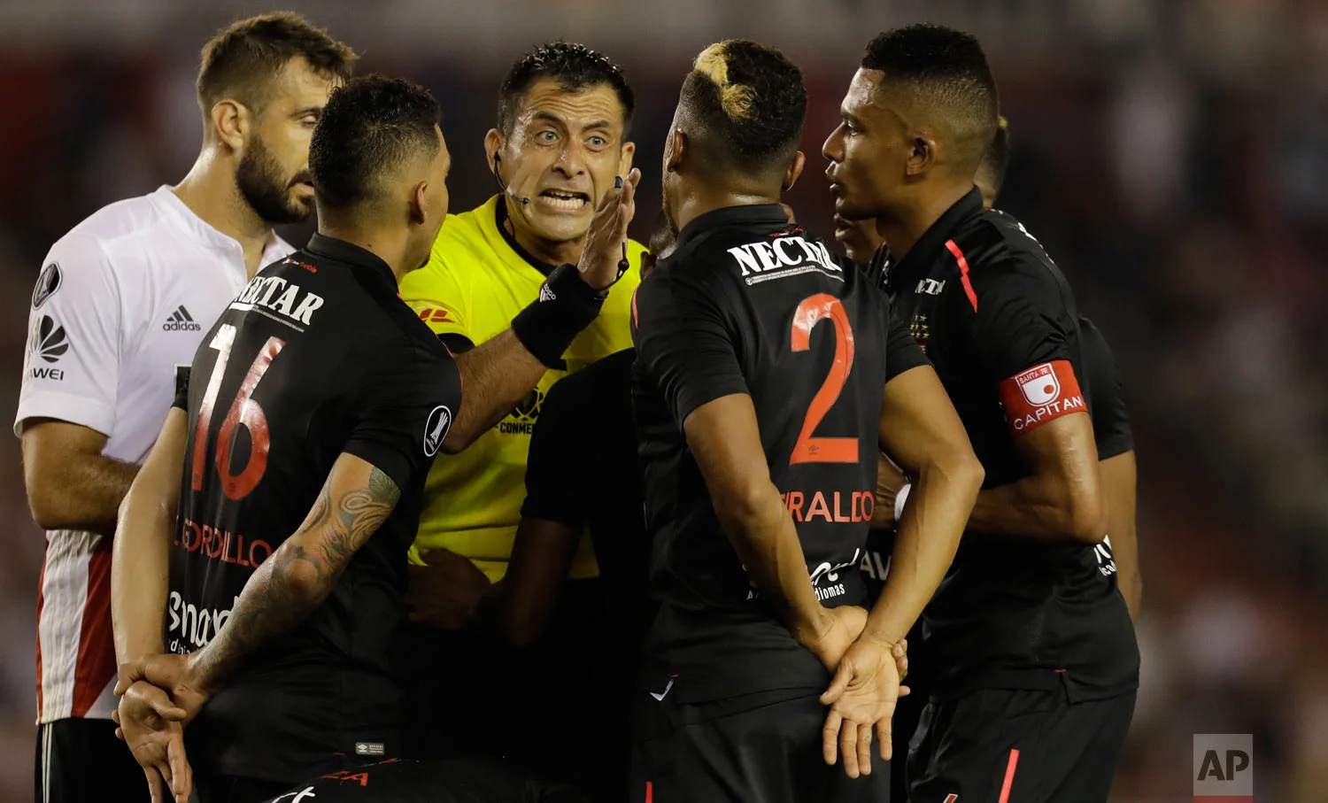 In this April 5, 2018 photo, Chilean referee Luis Bascunan yells at Colombia's Independiente Santa Fe players during a Copa Libertadores soccer match against Argentina's River Plate in Buenos Aires, Argentina. (AP Photo/Natacha Pisarenko)
