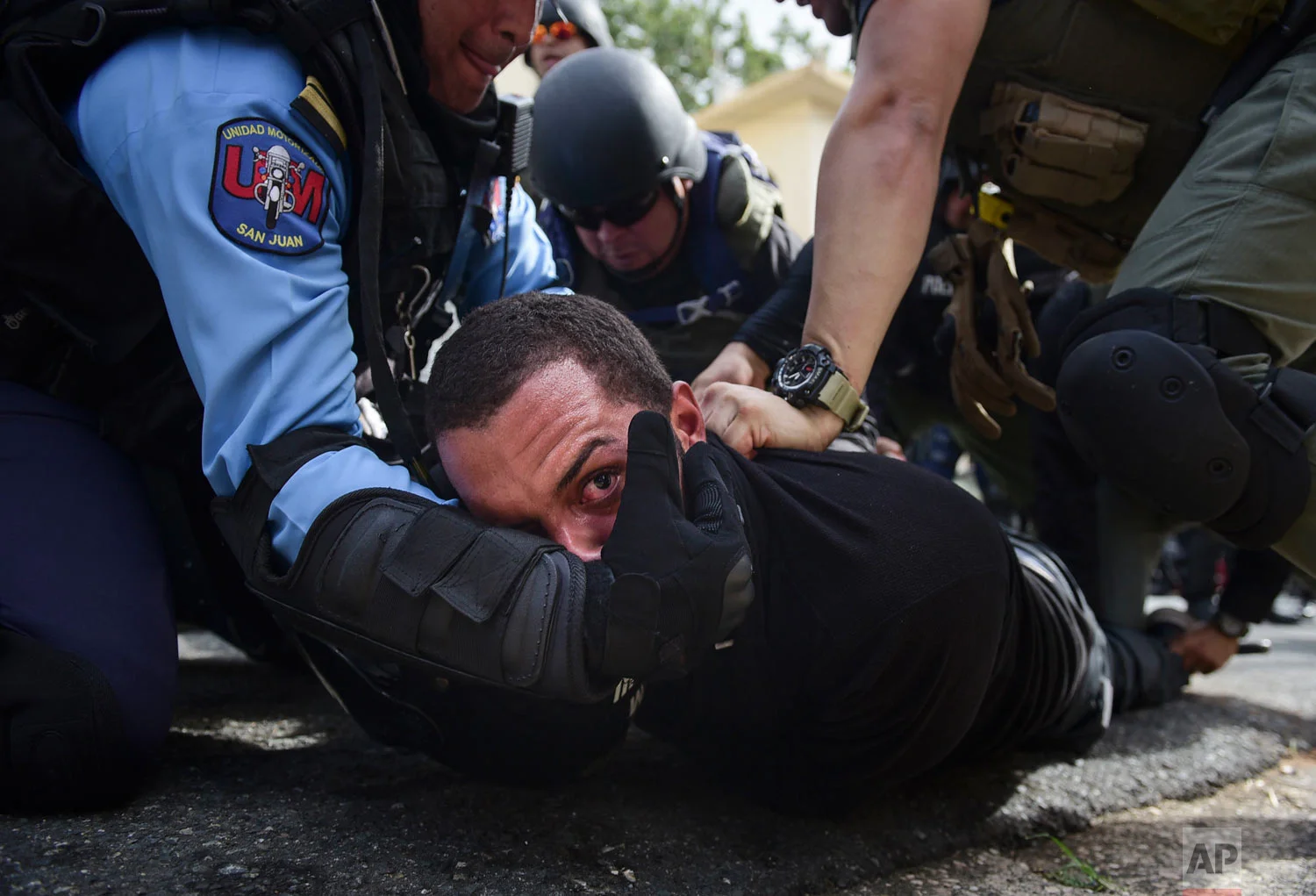 In this May 1, 2018 photo, police detain a protester after a May Day march where people protested pension cuts, school closures and slow hurricane recovery efforts in San Juan, Puerto Rico. Puerto Rico is struggling to emerge from a 12-year-old recession. (AP Photo/Carlos Giusti)