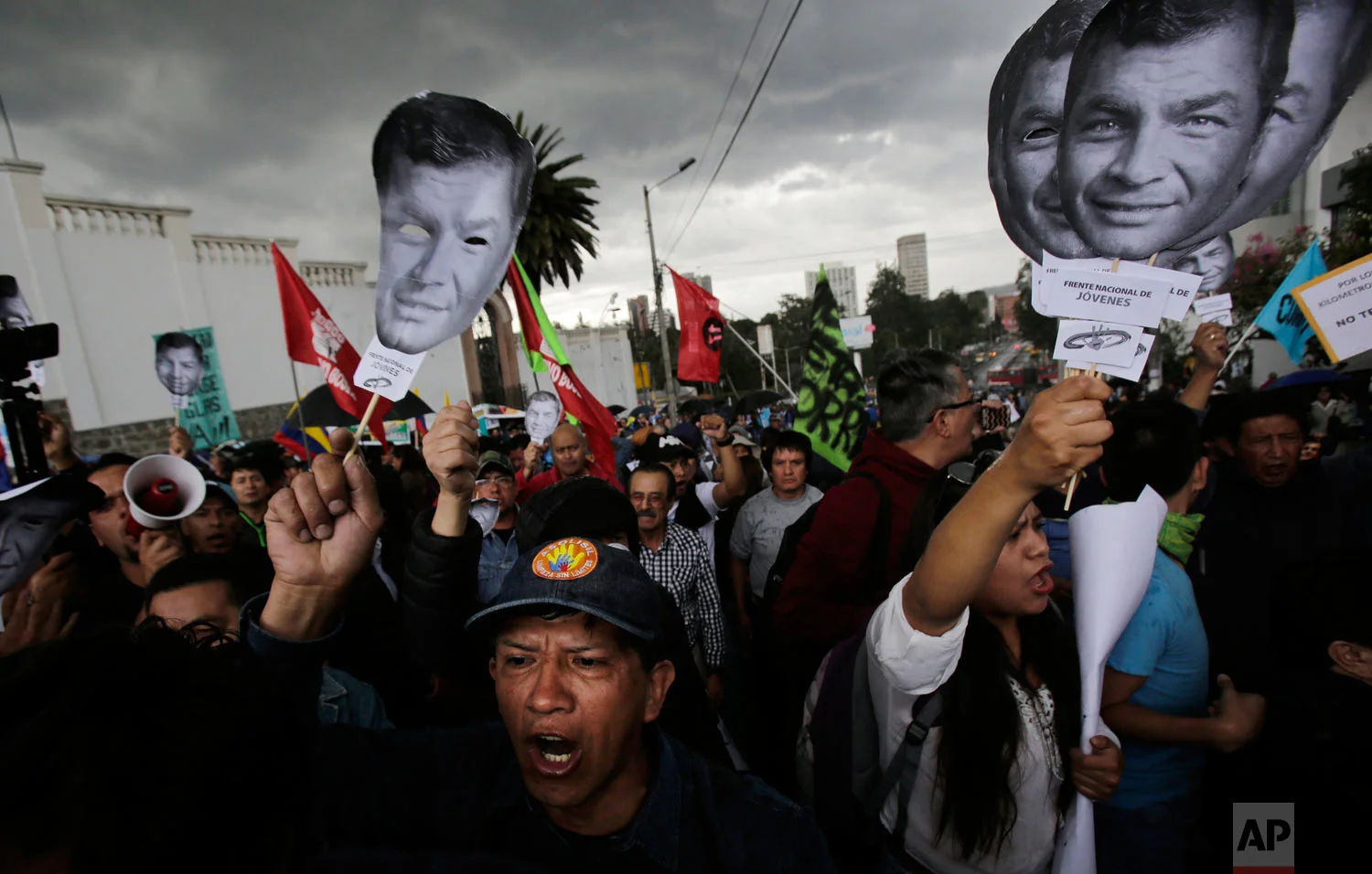 In this June 14, 2018 photo, supporters of Ecuador's former President Rafael Correa hold up images of his face to protest an attempt to prosecute him, outside the National Assembly in Quito, Ecuador. Correa has denied the allegation that he ordered the 2012 kidnapping of political rival Fernando Balda, saying it is part of a campaign by the current government to discredit him and destroy his leftist movement. (AP Photo/Dolores Ochoa)