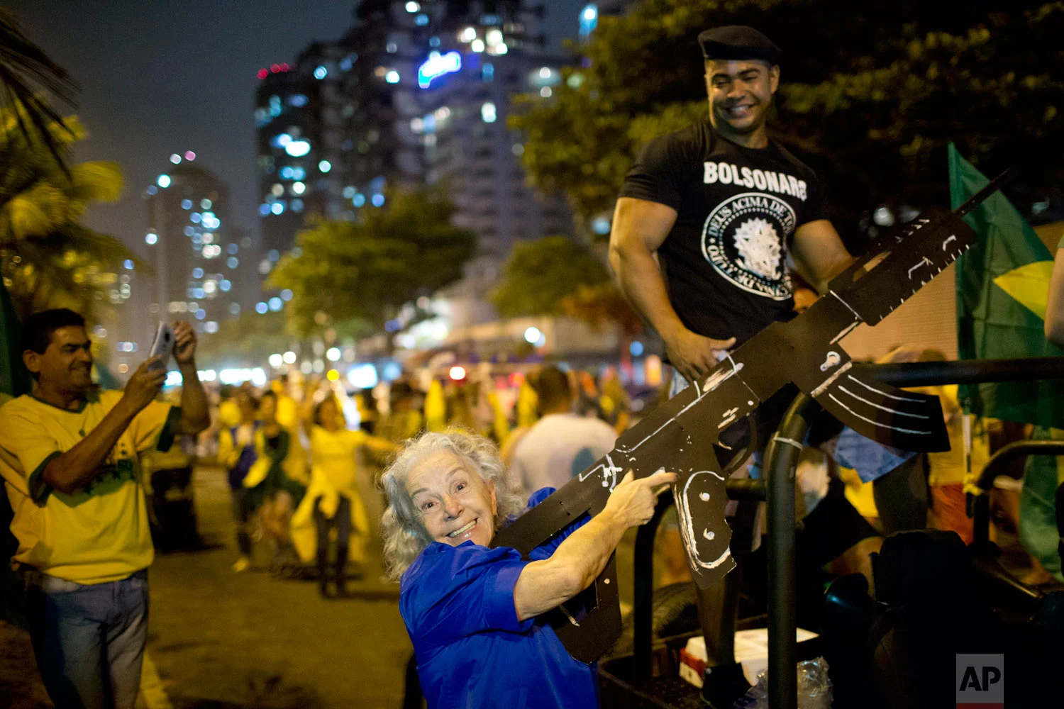 In this Oct. 28, 2018 photo, a supporter of presidential candidate Jair Bolsonaro poses for a photo with a mock rifle as she celebrates the election runoff results in Rio de Janeiro, Brazil. Brazil’s Supreme Electoral Tribunal declared the right-leaning congressman the next president of Latin America’s biggest country. (AP Photo/Silvia Izquierdo)