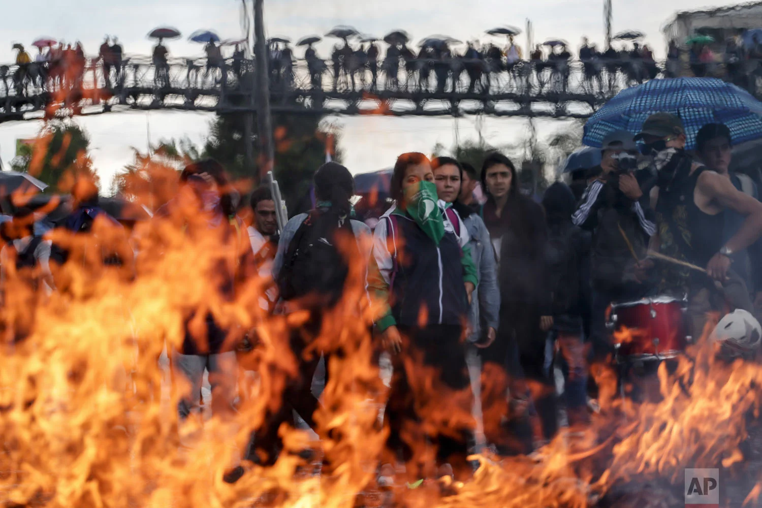 In this Nov. 28, 2018 photo, demonstrators burn banners during a march demanding more money for education and protest tax reform in Bogota, Colombia. Student unions are demanding the government spend at least $1.5 billion on public universities that have seen enrollment quadruple over the past two decades. (AP Photo/Ivan Valencia)