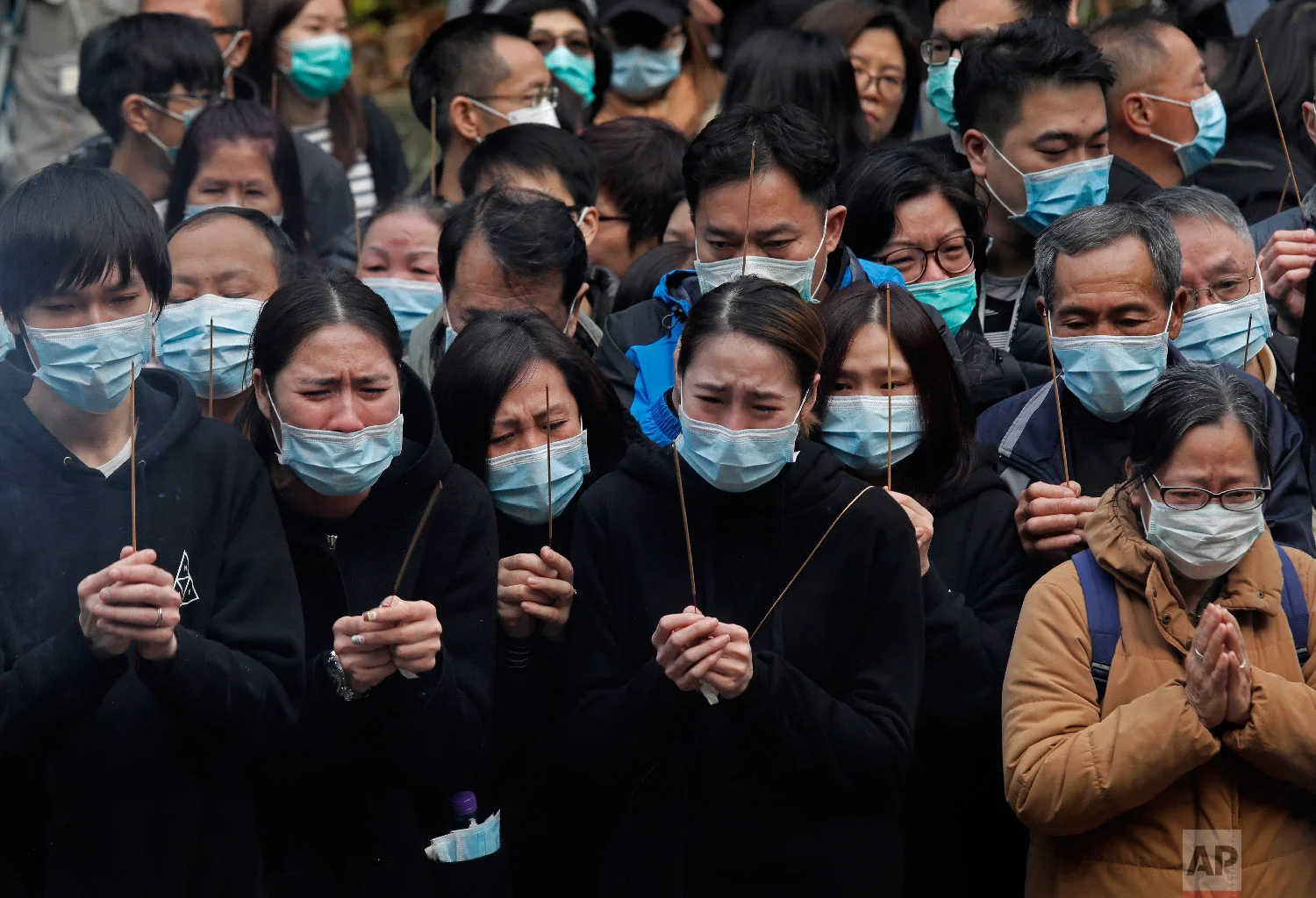 Relatives pay last tributes to victims of a bus crash in Hong Kong on Feb. 11, 2018. (AP Photo/Vincent Yu)