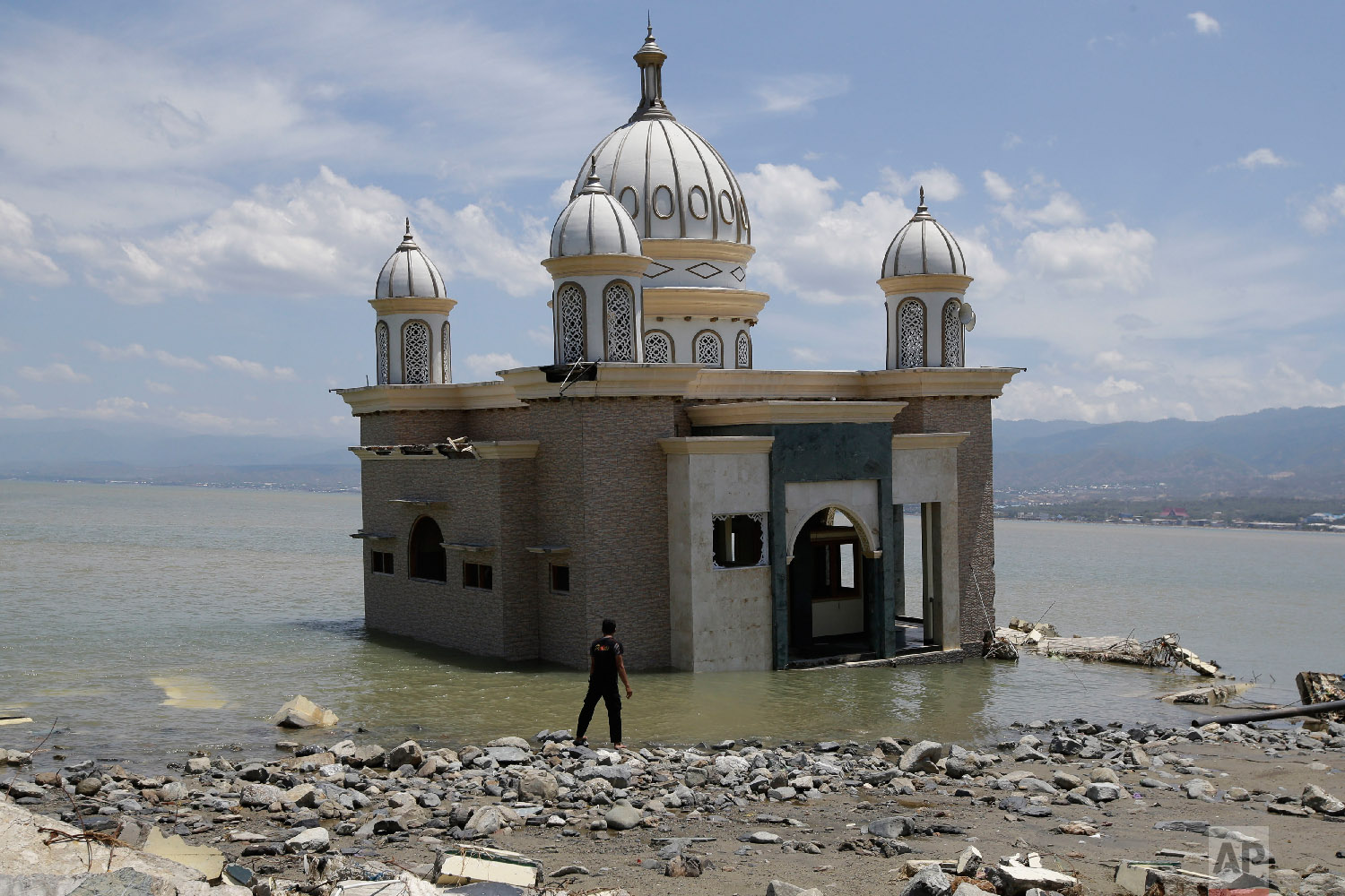  A man looks at a mosque that was isolated by water after its bridge was destroyed due to a massive earthquake and tsunami in Palu, Central Sulawesi, Indonesia, on Oct. 5, 2018. (AP Photo/Aaron Favila) 