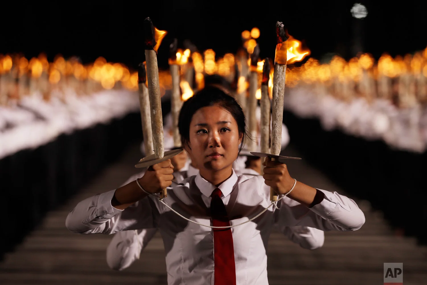 North Korean youths hold torches during a torch light march at the Kim Il Sung Square in conjunction with the 70th anniversary of North Korea's founding day in Pyongyang, North Korea, on Sept. 10, 2018. (AP Photo/Kin Cheung)
