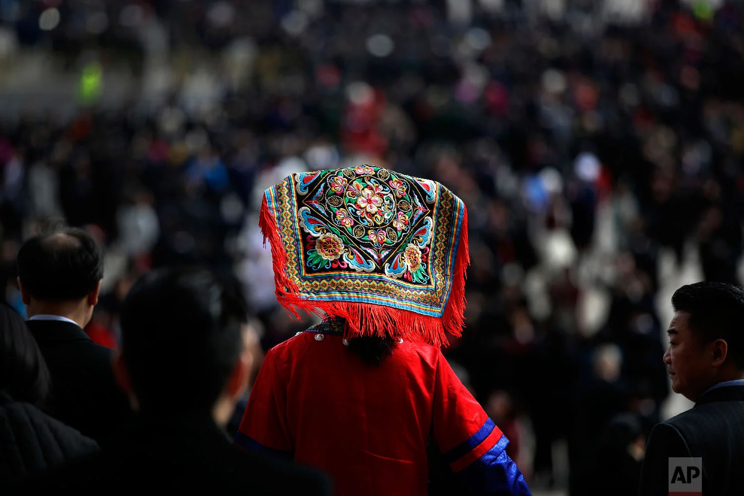 A delegate in an ethnic minority costume leaves the Great Hall of the People after attending the closing session of the annual National People's Congress (NPC) in Beijing, on March 20, 2018. (AP Photo/Andy Wong)
