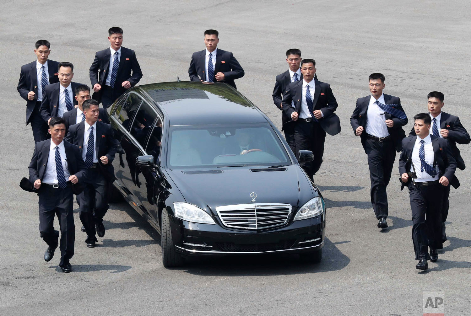  North Korean security personnel run by a car carrying North Korean leader Kim Jong Un returning to the North side for a lunch break after a morning session of the summit with South Korean President Moon Jae-in at the border village of Panmunjom in D