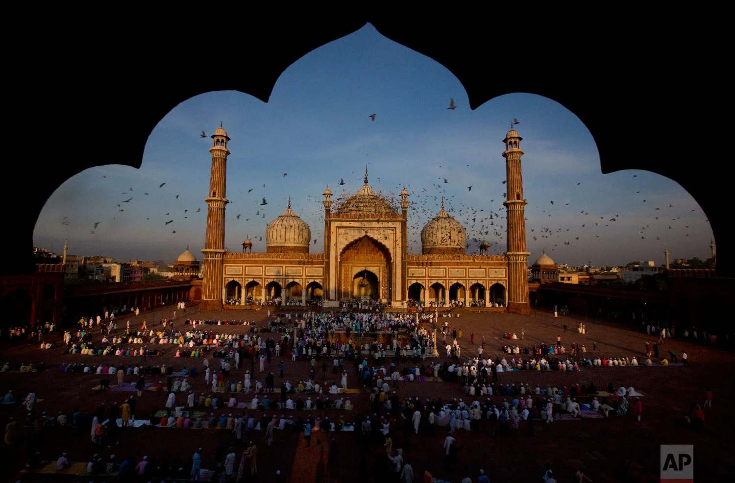 Pigeons fly past as Muslims gather to offer Eid al-Adha prayers at Jama Masjid in New Delhi, India, on Aug. 22, 2018. (AP Photo/Manish Swarup)