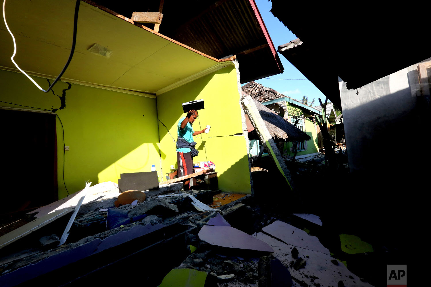  Usable items are salvaged from a home destroyed in a powerful earthquake in North Lombok, Indonesia, on Aug. 6, 2018. (AP Photo/Tatan Syuflana) 