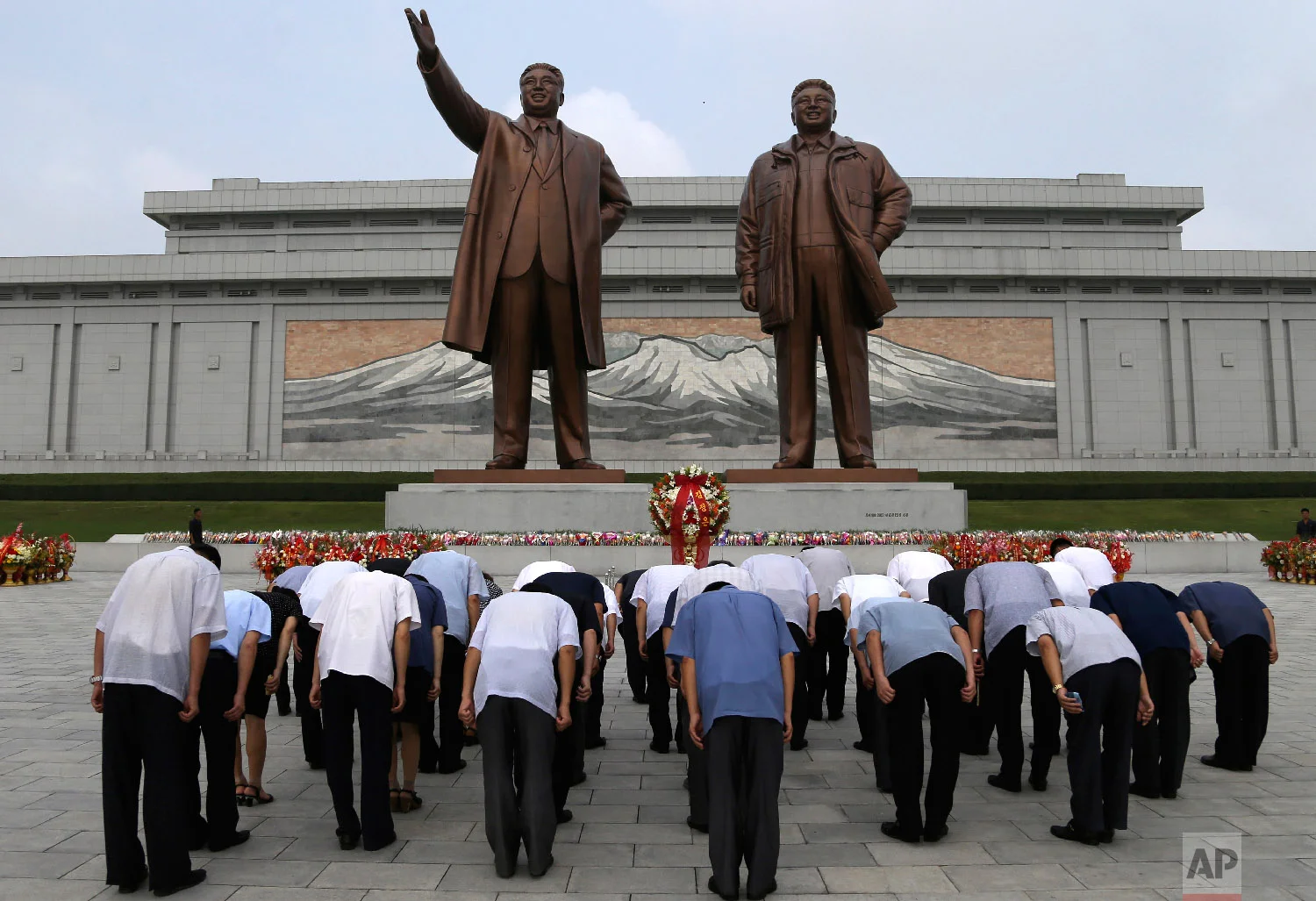 North Korean men bow at the giant bronze statues of late North Korean leaders Kim Il Sung and his son Kim Jong Il during the commemoration of the 65th anniversary of the ceasefire armistice that ended the fighting in the Korean War, which the country celebrates as the day of "victory in the fatherland liberation war" at Mansu Hill Grand Monument in Pyongyang, North Korea, on July 27, 2018. (AP Photo/Dita Alangkara)