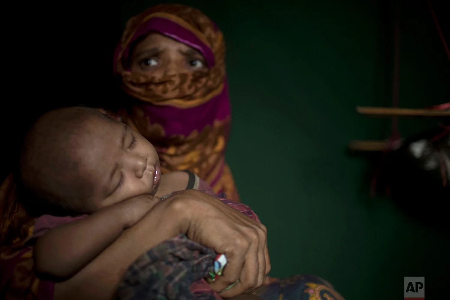 "S" holds her baby boy as she sits in her shelter in Balukhali refugee camp in Bangladesh on June 25, 2018. "S," a widow, was so worried about her neighbors discovering her pregnancy that she suffered silently through labor in her shelter, stuffing a scarf in her mouth to swallow her screams. (AP Photo/Wong Maye-E)