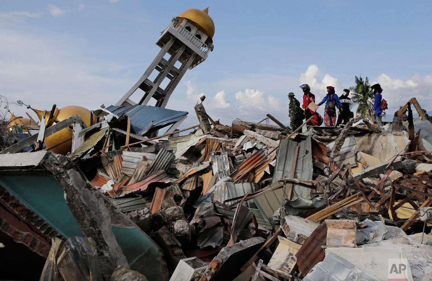 Rescuers and villagers wait for news for their missing loved one's as recovery efforts continue after liquefaction hit the neighborhood of Balaroa in Palu, Central Sulawesi, Indonesia, on Oct. 6, 2018. (AP Photo/Aaron Favila)